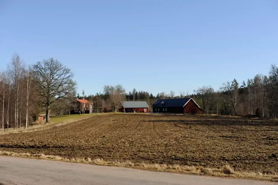 Åker med gård som fond.